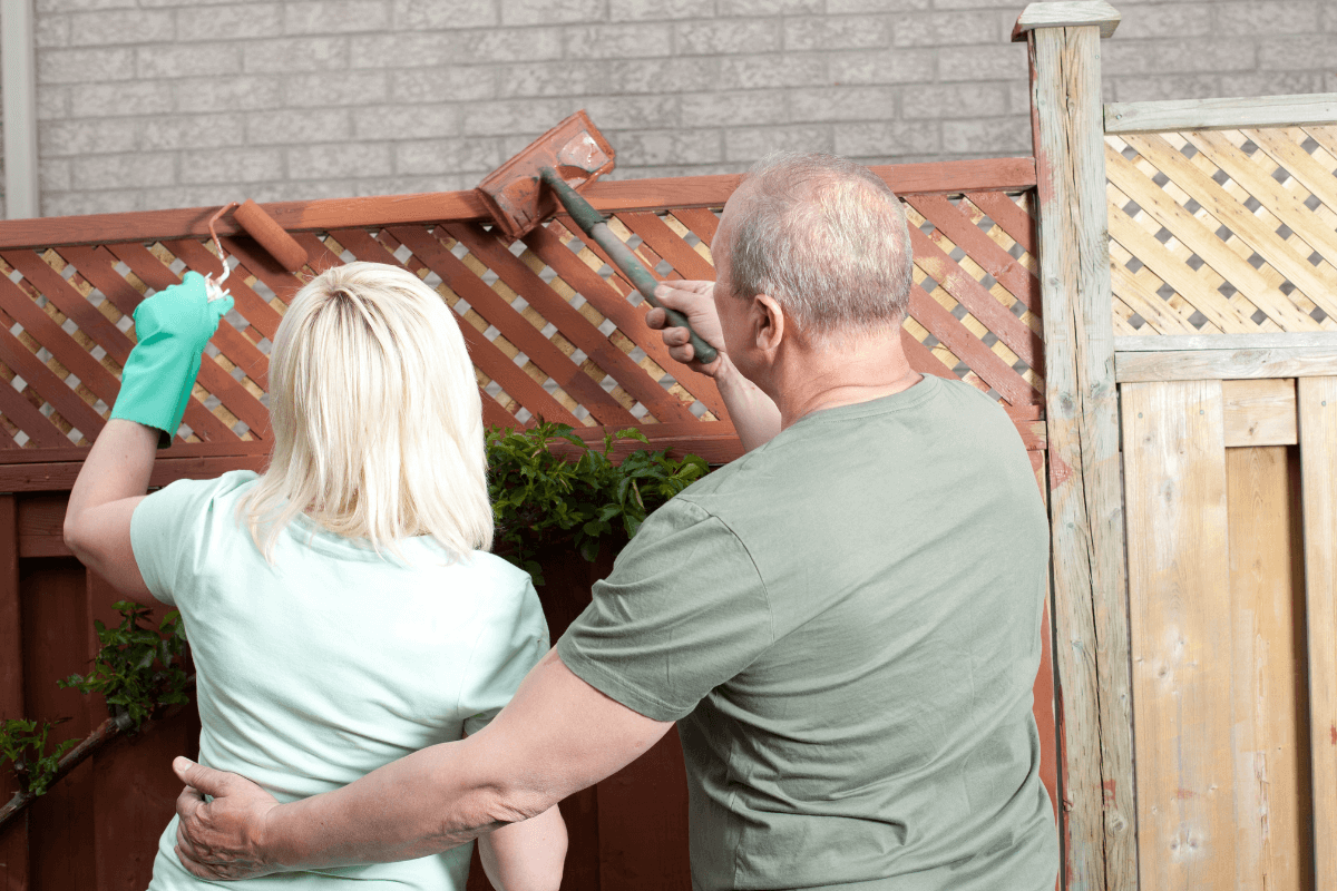 couple painting garden fence diy